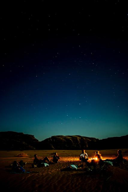 people sitting by fire 
