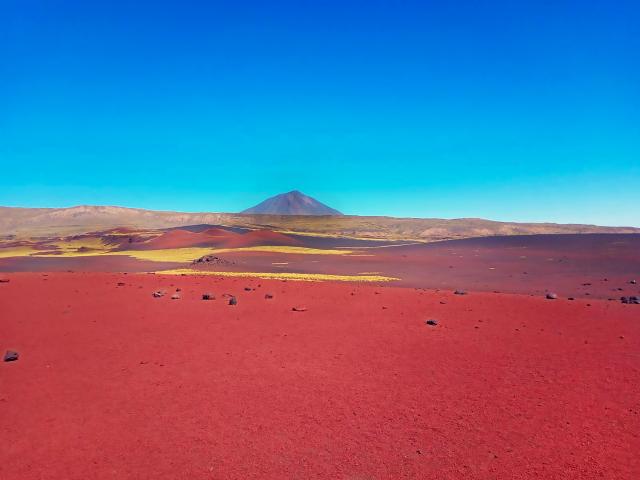 Multicolored sand landscape with mountain in distance