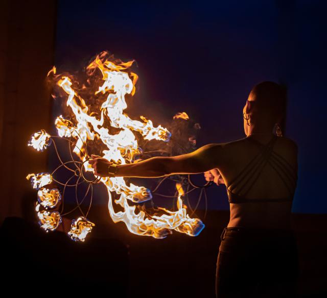 person swings flaming wires
