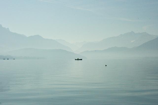 A boat on a lake in front of mountains
