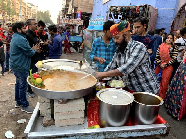 Man cooking outside in the street.