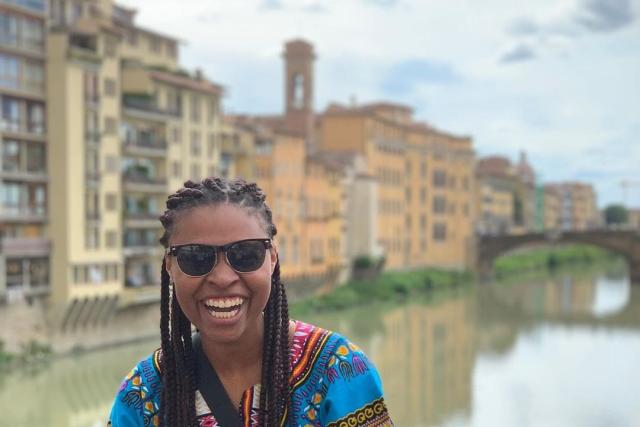 Young woman poses in front of Italian canal