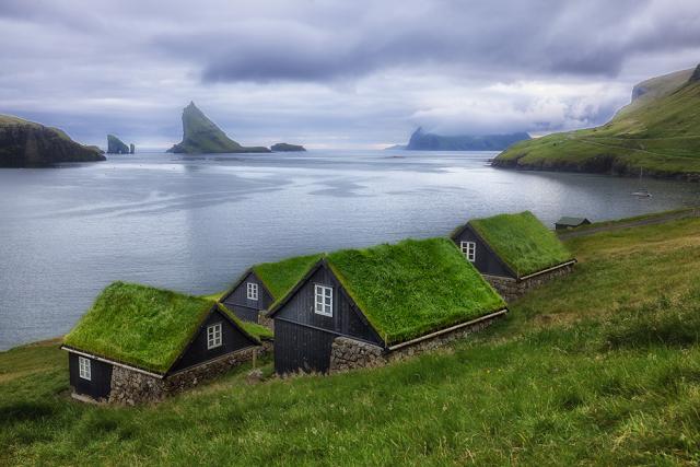 Houses set into a hillside with grass roofs.