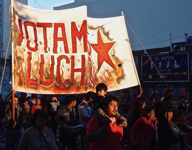 Argentinian protestors carrying a sign at sunset