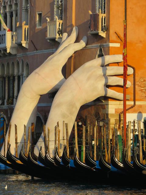 Hand sculpture on side of building 