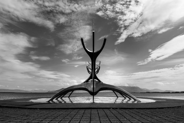 sculpture in front of body of water