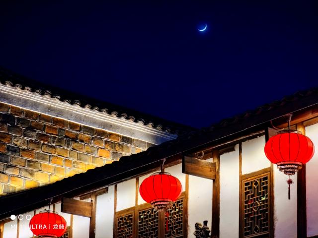 Night sky with crescent moon in front of paper lanterns