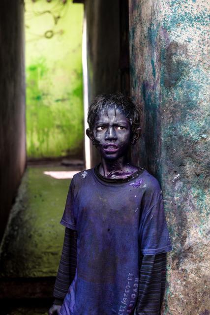 Boy covered in purple paint during Holi celebration