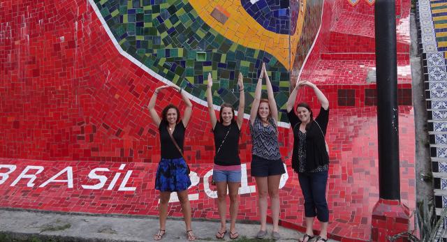 Students in front of a Brazilian Flag Mosiac making O-H-I-O