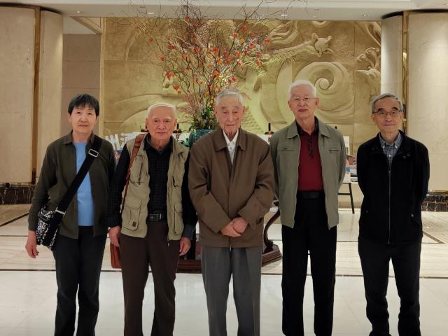 Five individuals post in a restaurant lobby