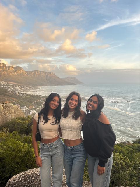 Students posing overlooking rocky coastline