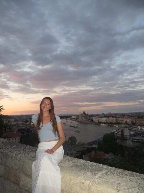 Student posing near city skyline