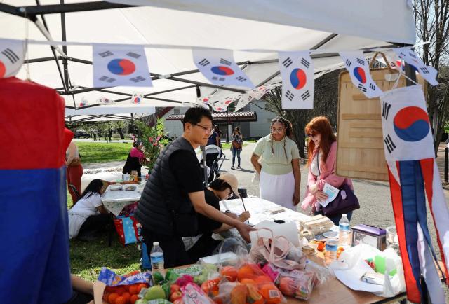 Man working cultural booth with Korean flags
