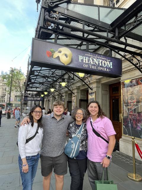 Four students in London in front of a theatre