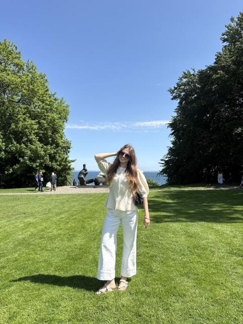 Student posing in a grassy area