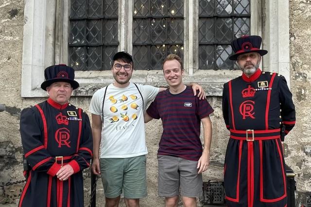 Two young men pose with UK guards