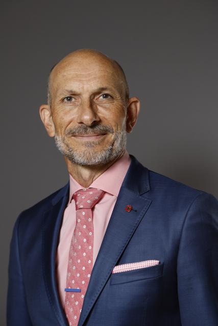 Male wearing suit with pink shirt and pink tie.