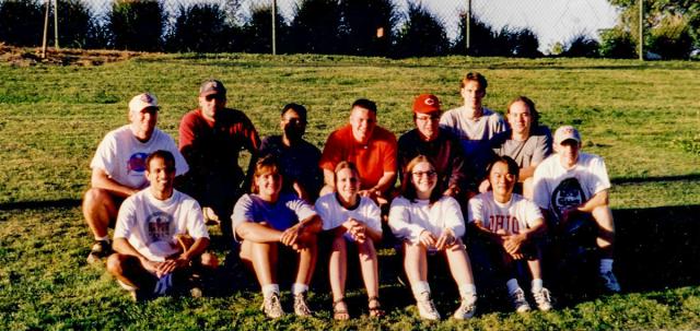 Group of college students sitting on grass hill.