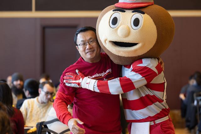 Thanksgiving dinner volunteer and Brutus are hugging