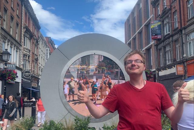 Young man poses in front of Irish sculpture