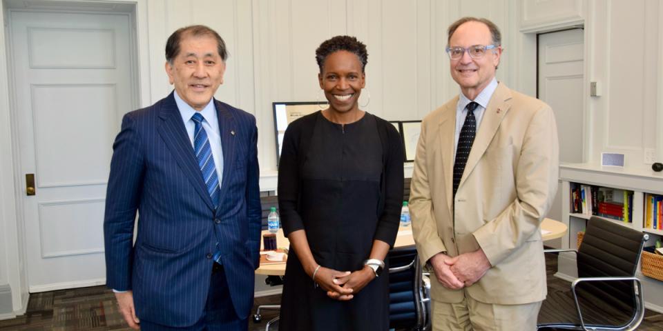 Two men and a woman in business suits meet in office