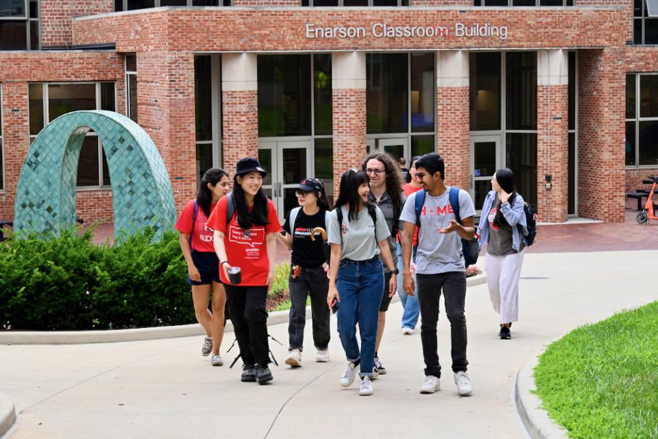 Group of students walking outside of campus building.