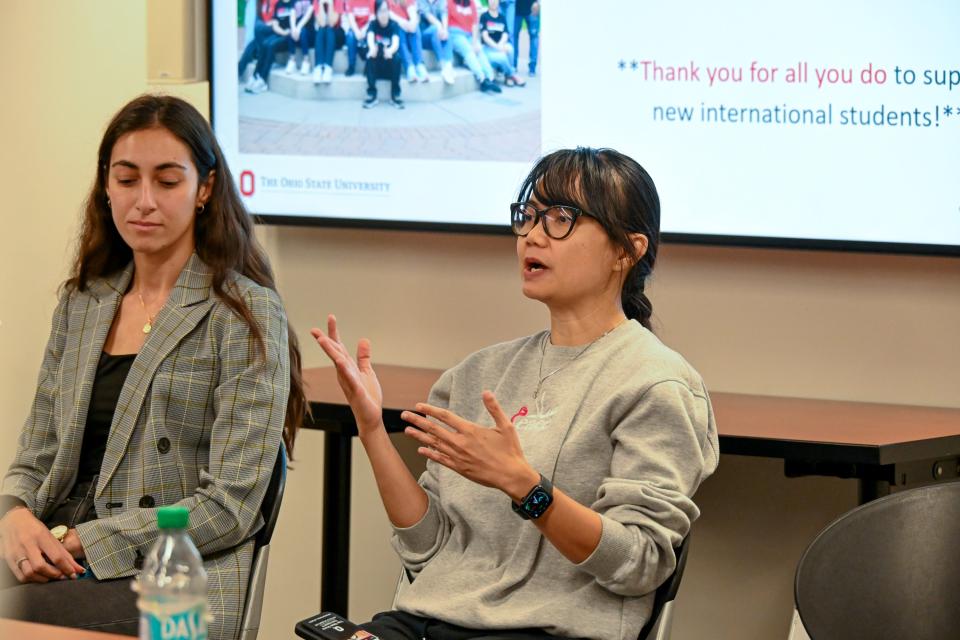 International student speaking to a group of staff and faculty