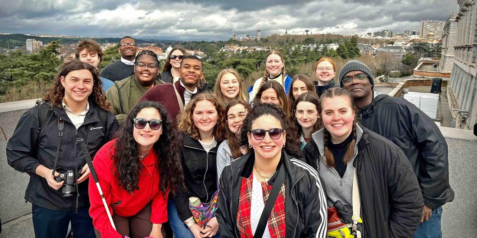 students and staff posing overlooking a city