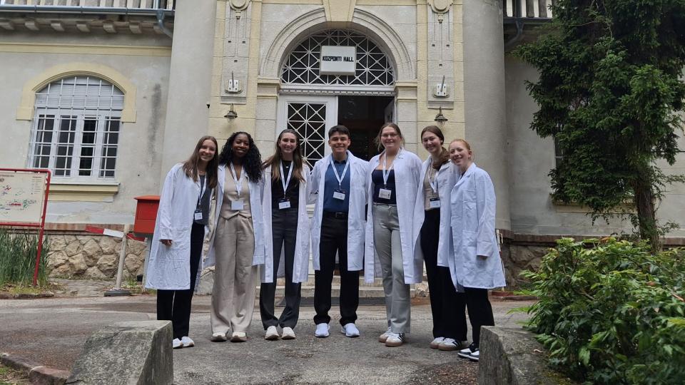 People in lab coats standing outside medical center