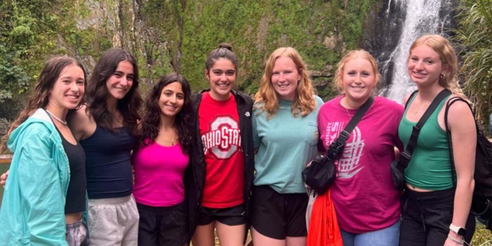 students near a waterfall in the jungle