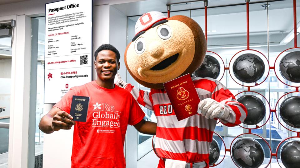 A student and Brutus hold up passports