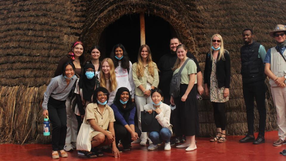 Students outside of a hut