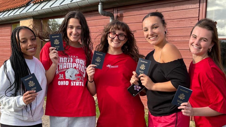 students holding up passports