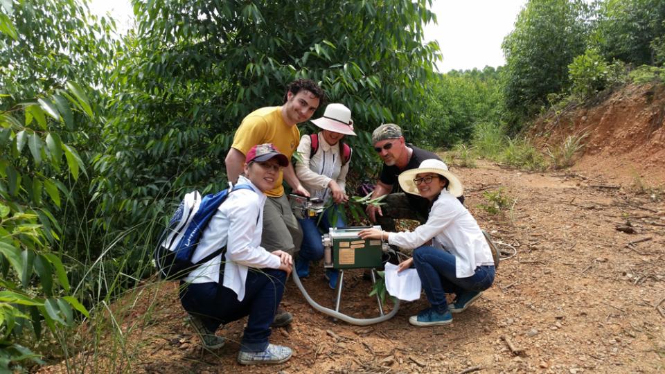 Roger Williams works on a machine in the Guangxi Forest assisted by students