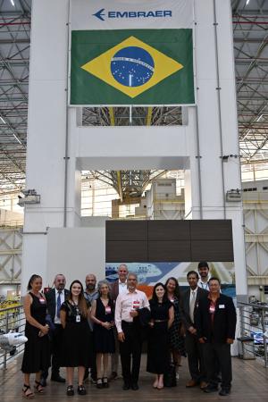 The Ohio State delegation standing under the Embraer logo and Brazil flag.