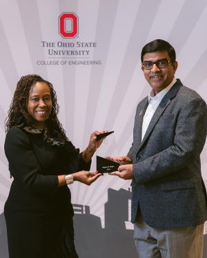 Woman and man hold award together