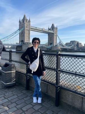 Woman standing with Tower Bridge in background.