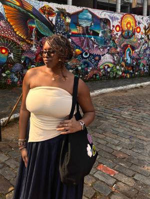Woman looks away in front of colorful mural