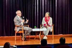 Two people in conversation seated on stage.