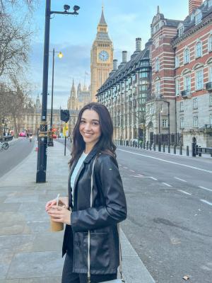 Woman holding drink standing in street