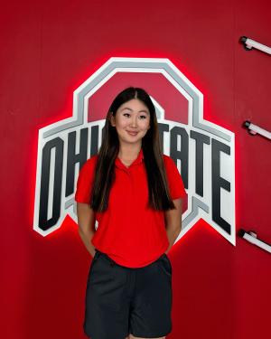 Student posing in front of Ohio State logo