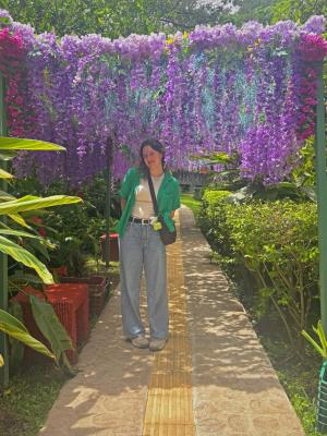 student standing near a flower wall