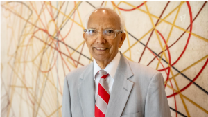 Rattan Lal in gray suit and scarlet and gray tie.