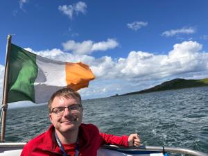 Young man on a boat with an Irish flag