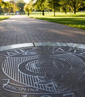 A seal of The Ohio State University on the Oval.