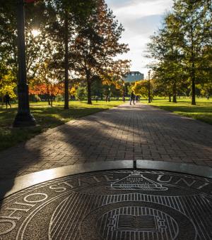 A seal of The Ohio State University on the Oval.